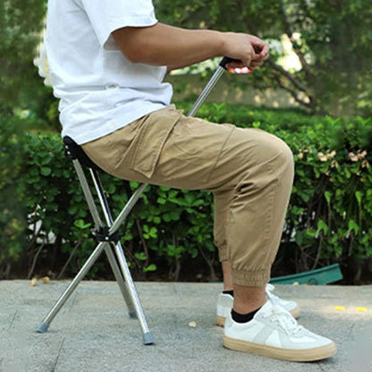 Person using the lightweight folding cane at a concert then sitting comfortably on the builtin sea